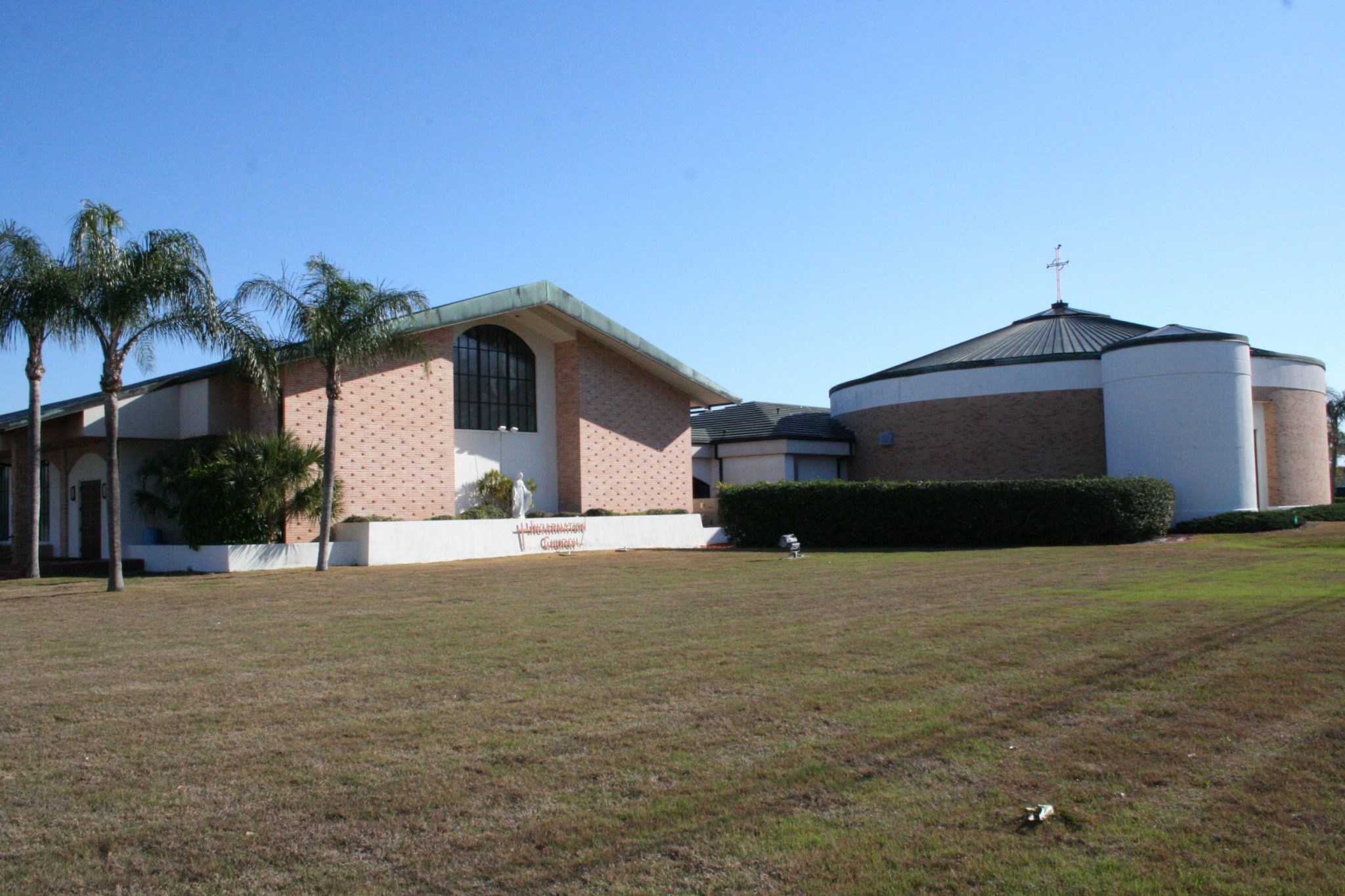 Incarnation Catholic Church exterior in Sarasota with palm trees and church buildings.